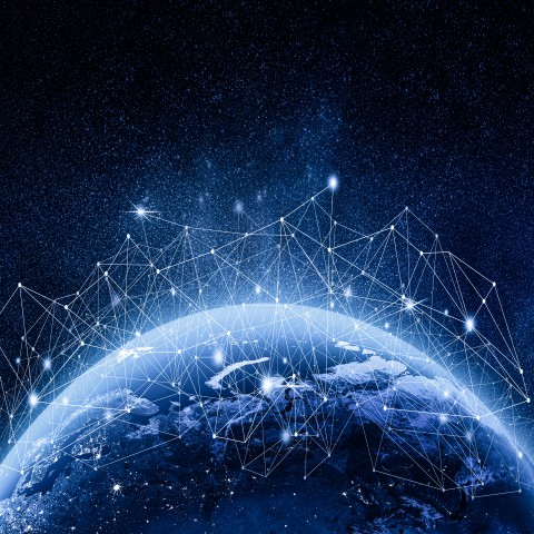 Globe terrestre entouré d’un réseau de points connectés sur fond étoilé