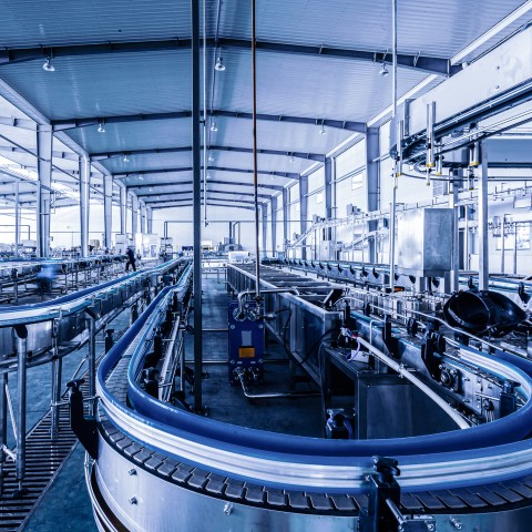 Hall de production industriel avec convoyeurs et lignes d’assemblage