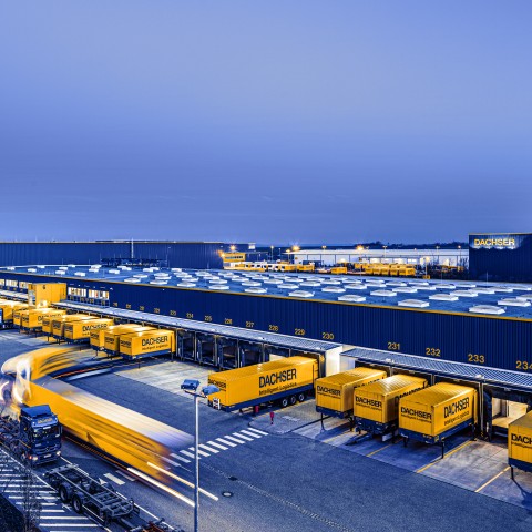 Vue aérienne d’un centre logistique DACHSER au crépuscule, avec de nombreuses portes de quai et des caisses mobiles DACHSER